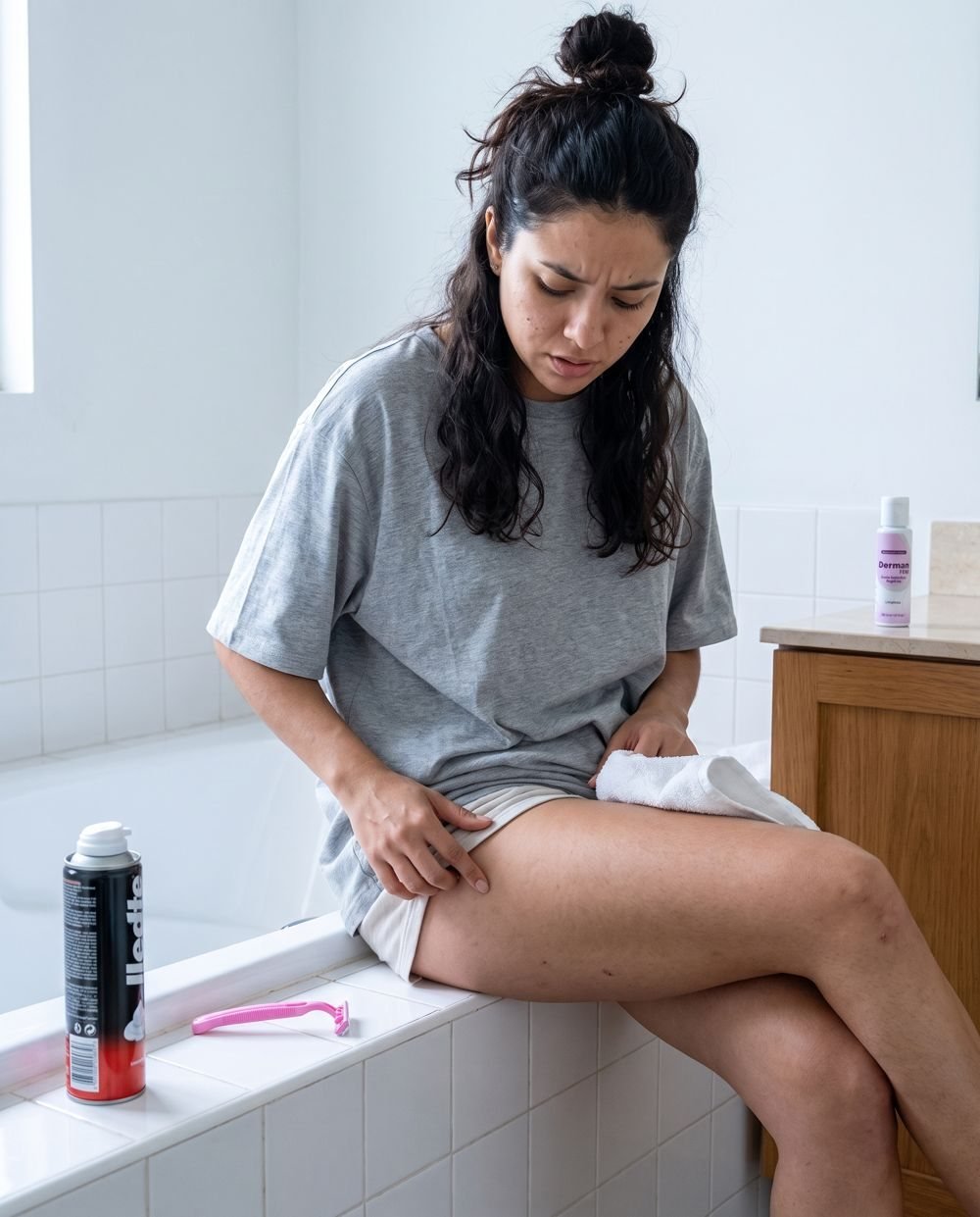 Antes: mujer incómoda sentada en el baño después de depilarse